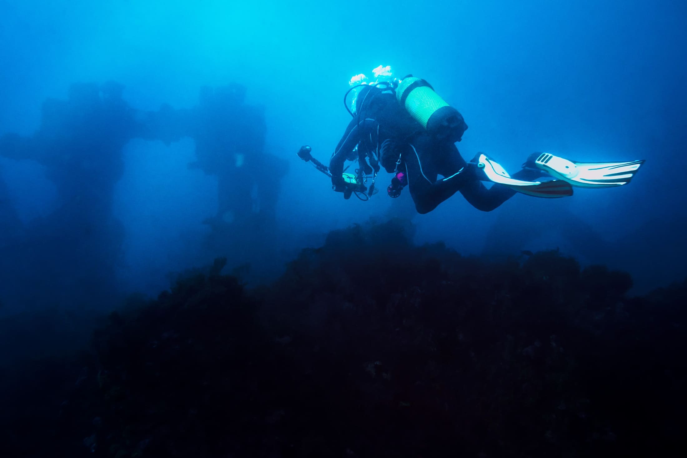 Scuba diving towards underwater ruins