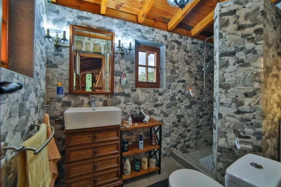 A picture of a stone villa bathroom with a walk-in shower