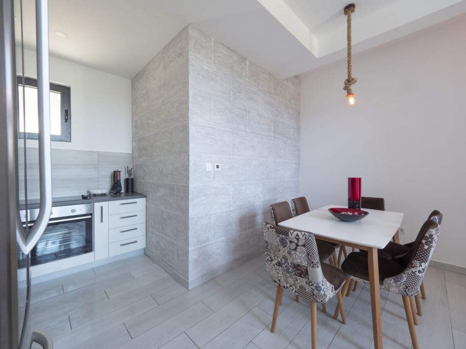 Dining area and a fully equipped kitchen inside a villa in Budva