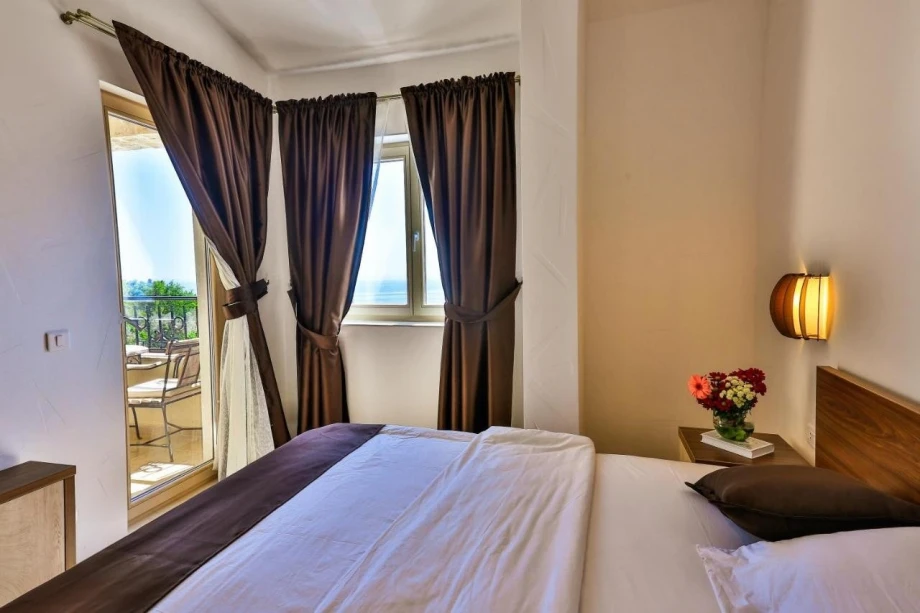 Bright and elegant bedroom with a comfortable bed for two in a villa for rent in Montenegro