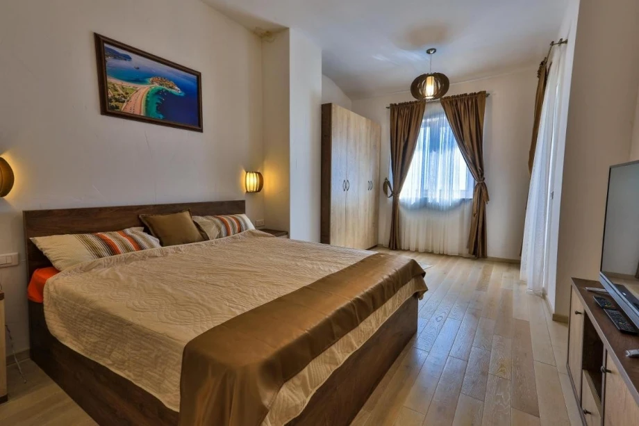 Bedroom with double bed and a TV in Villa Calia