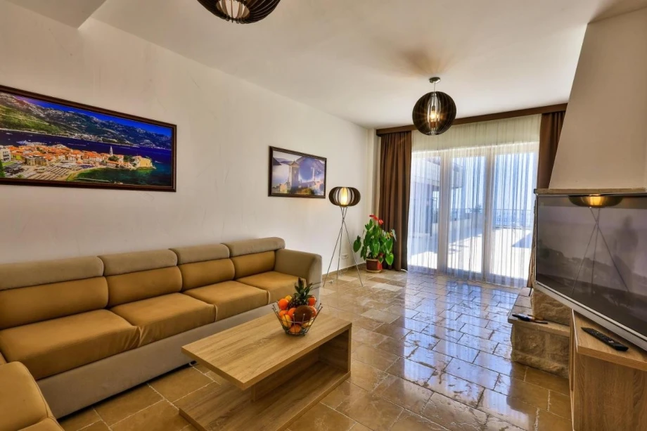 Lounge area with large sofa and TV inside a luxury villa for rent in Montenegro