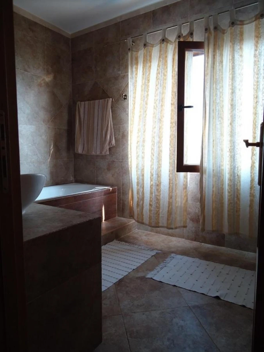 Bathroom with a bathtub and long curtains