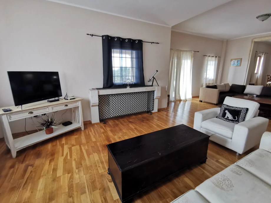 Living room with comfortable furniture, TV and a small window in the luxurious villa Rustica Mediteranea in Budva