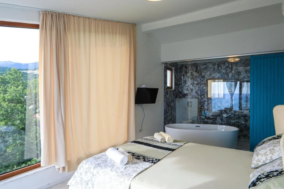 Elegant bedroom with a double bed and an open bathroom in the Villa Blissful Retreat