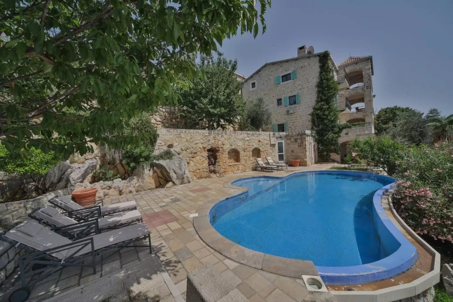 Large outdoor pool with sunchairs in a luxury villa for rent in Montenegro