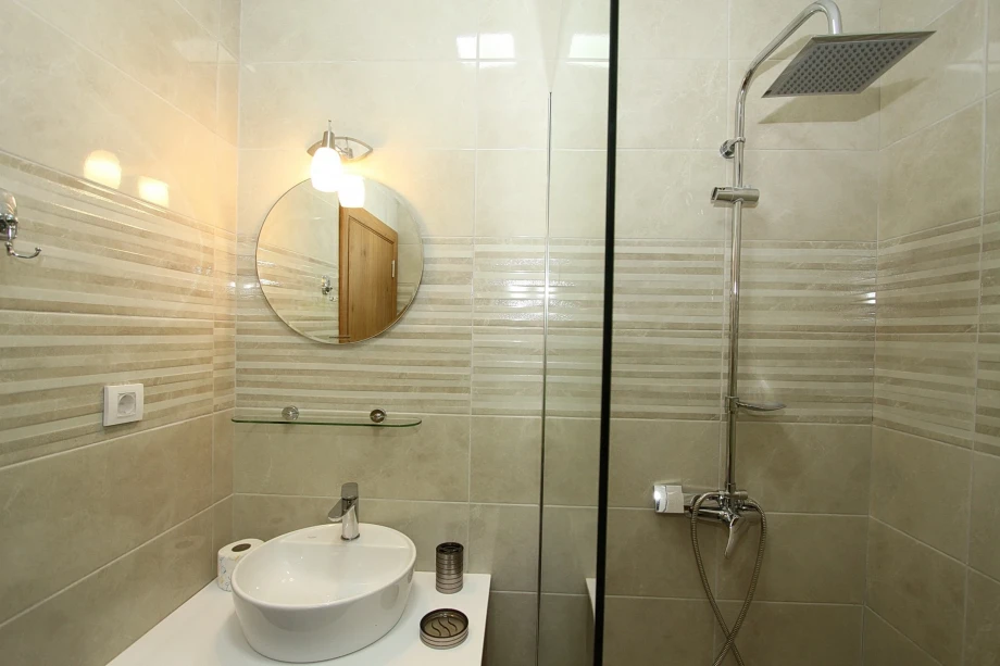 Bathroom with Round Mirror and Large Walk-In Shower