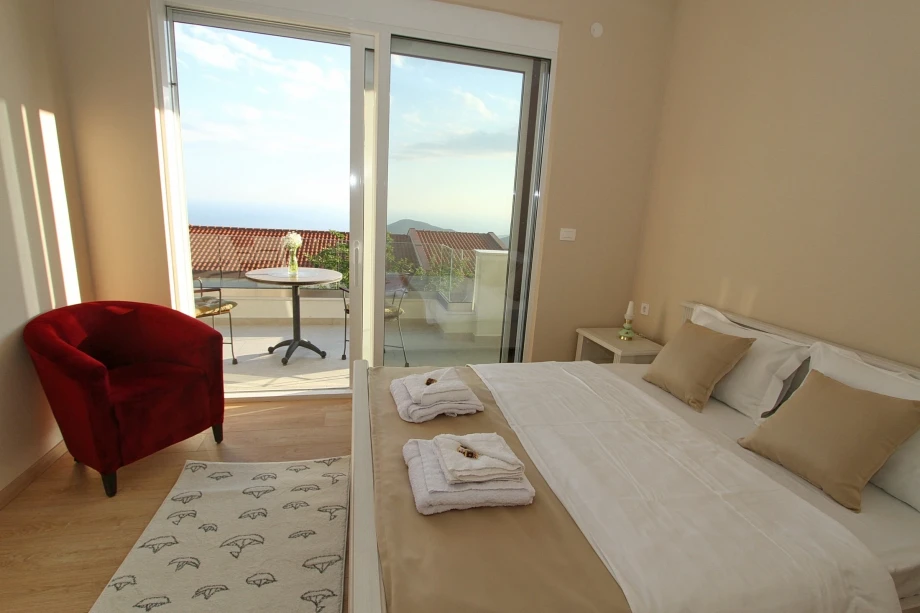 Bedroom with a terrace and a red armchair, Moonstruck Villa with Pool in Budva