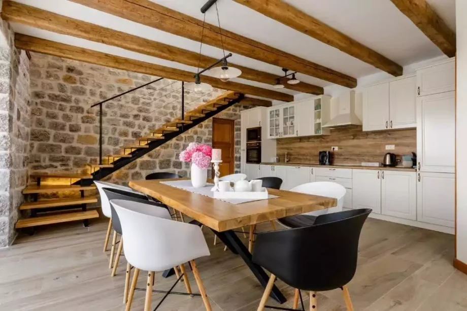 White and spacious kitchen with a dining table in the elegant villa Poetica in Montenegro