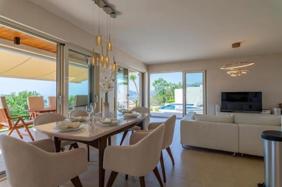 A large dining table with comfortable chairs and a beautiful view of the Adriatic Sea in the luxurious Endless Blue Villa