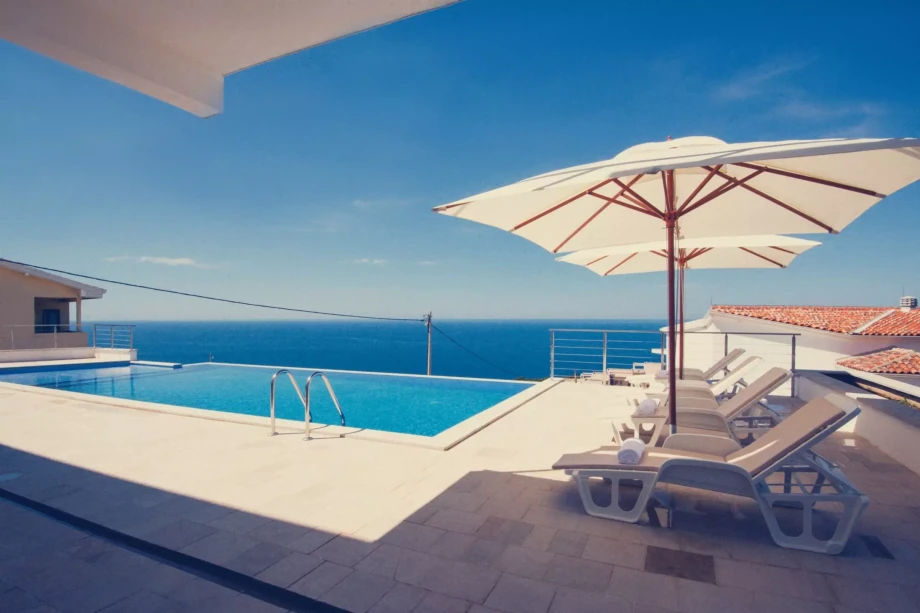 Sundeck chairs and an outdoor pool of a luxury villa in Budva