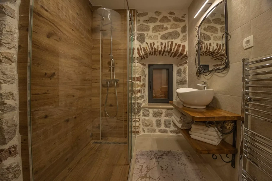 Shower cabin and sink in the beautifully decorated bathroom of Beachfront Villa Casa di Onda Bianca in Boka Bay