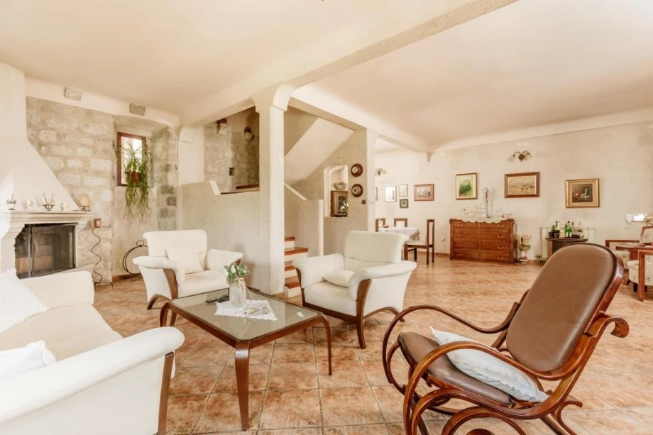 " Spacious living room with unique furniture and a fireplace in the elegant villa for rent in Kotor