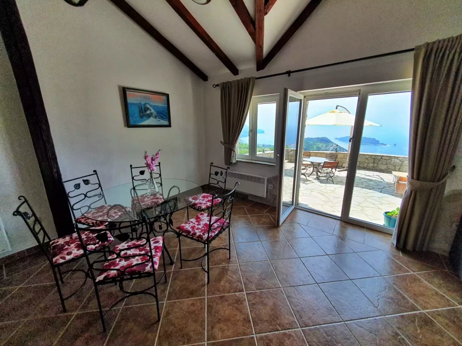 Flowery chairs inside a villa and a panoramic terrace