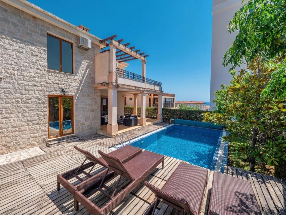 Relaxing View of the Outdoor Pool Area with Sun Loungers at the Villa