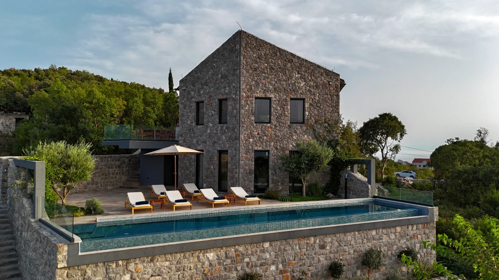 Elegant stone villa with serene poolside view at sunset in Montenegro