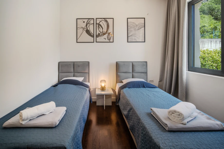 Villa bedroom with two single beds and cozy décor
