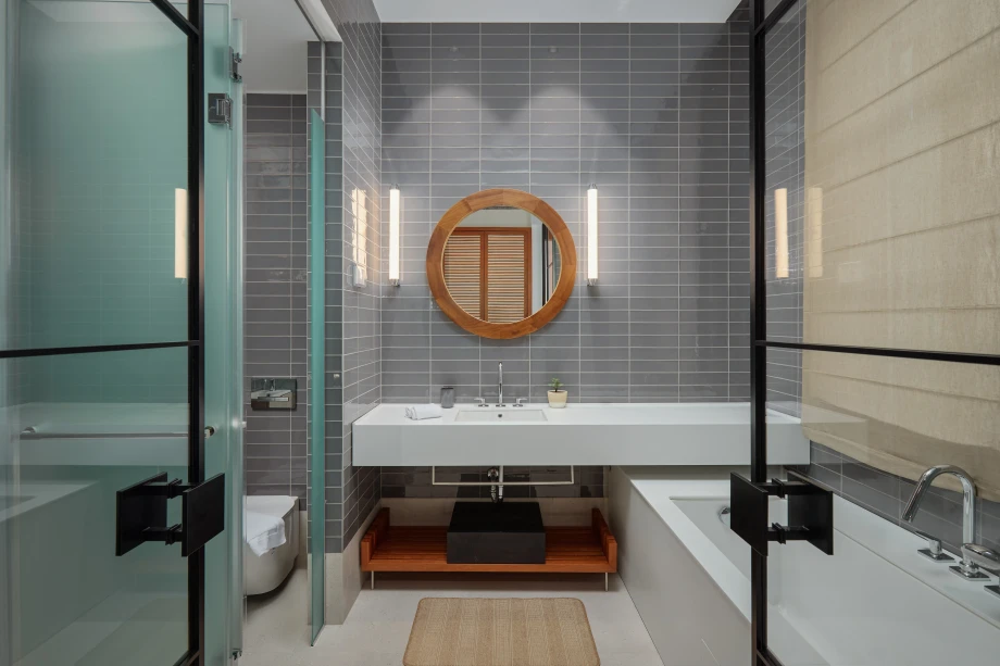Modern Grey-Tiled Villa Bathroom with Wood Accent Mirror and Glass Shower