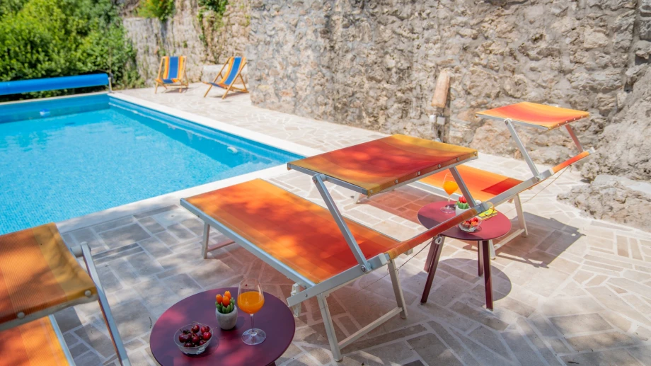 Sun loungers beside the private villa pool and landscaped garden
