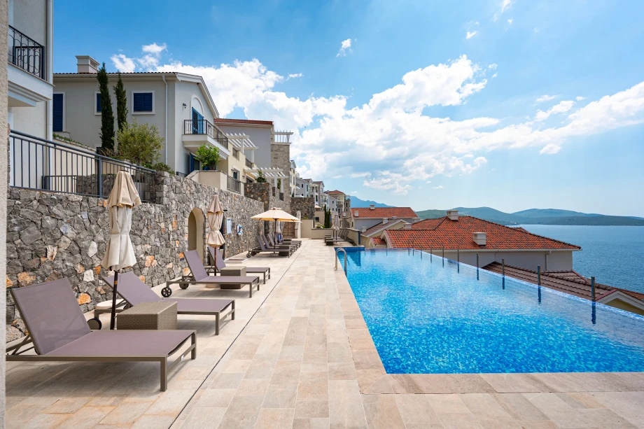Poolside Sun Loungers and Shaded Relaxation Area at Coastal Elegance Residences